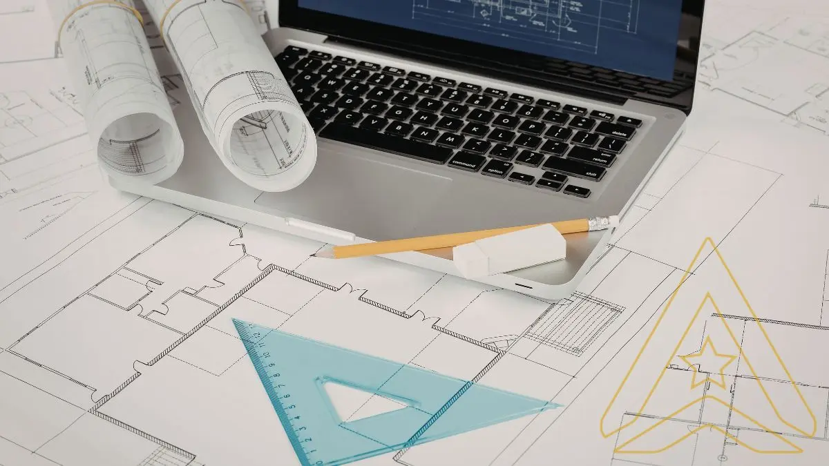 Laptop on blueprints with rolled plans, pencil, eraser, ruler. Logo of AXANH.
