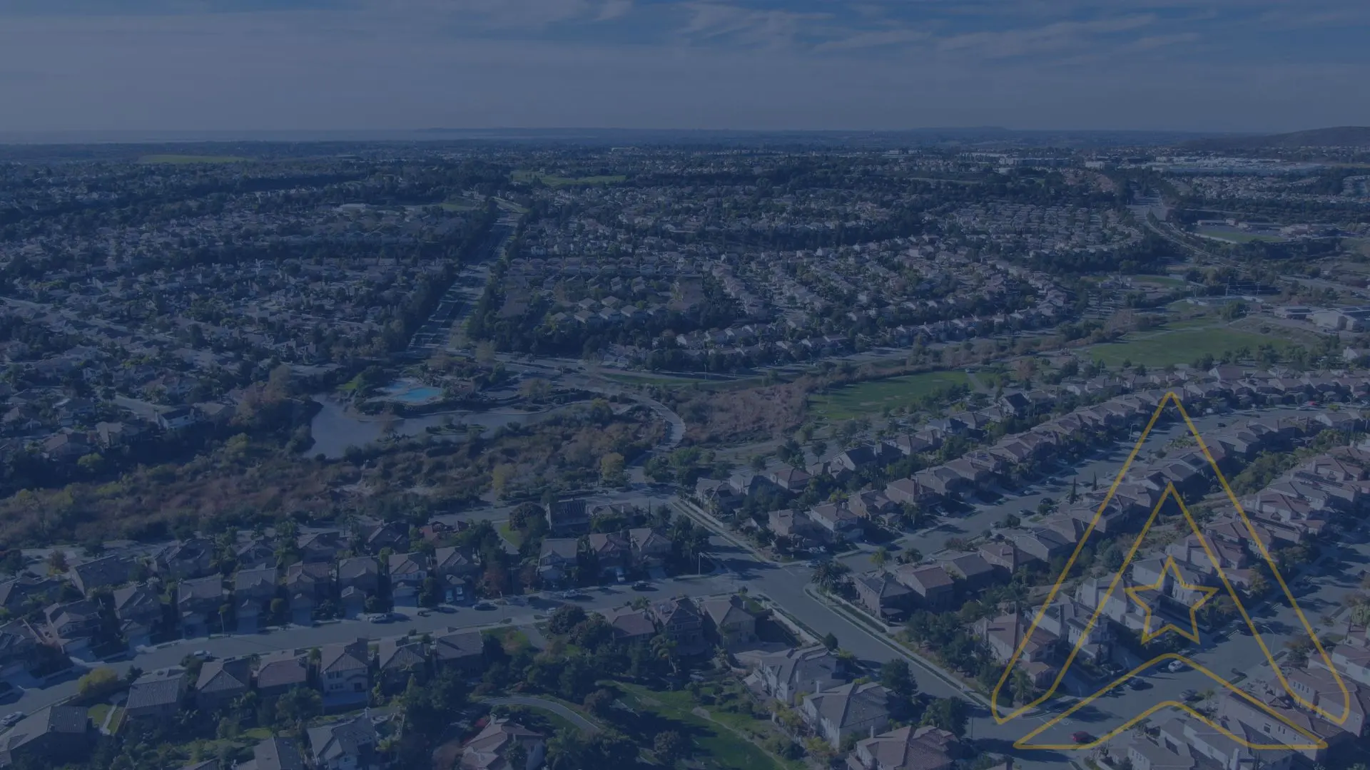 Aerial view of houses, winding streets, green areas, lake; AXANH Capabilities logo in corner.