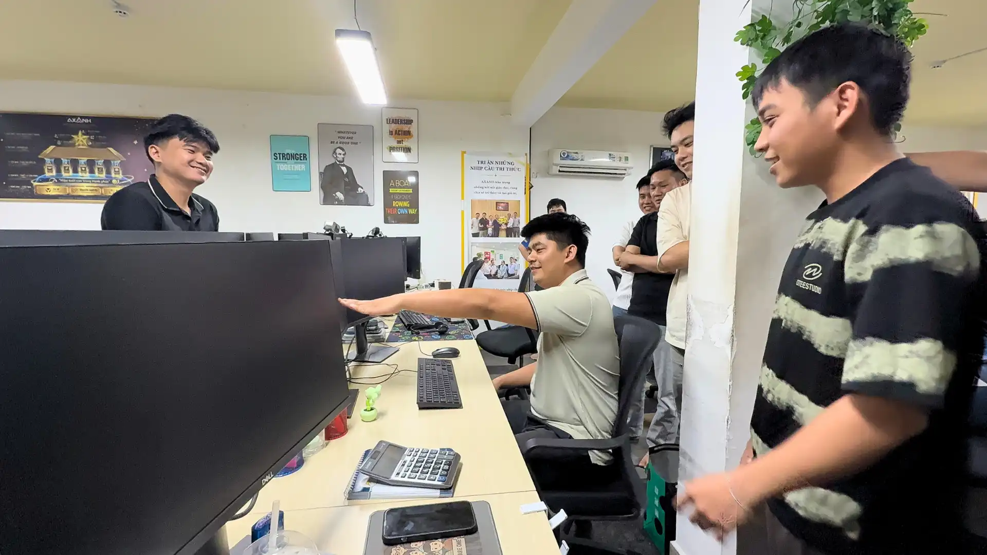 An AXANH team member adjusting a monitor and workstation