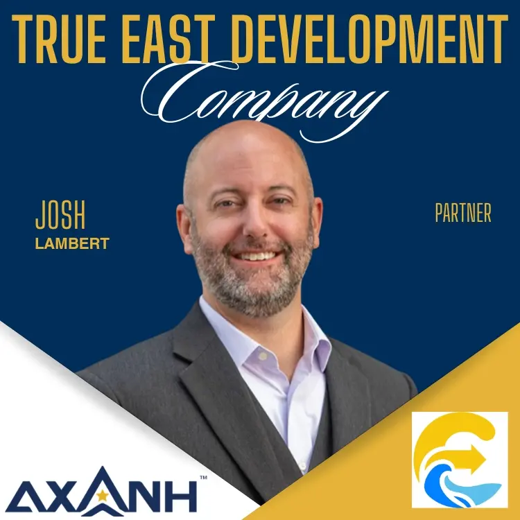Smiling bald man with beard in suit, Josh Lambert, Partner, AXANH. Logo of AXANH.