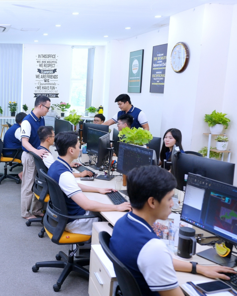 People working at computers in a bright office with plants and posters.